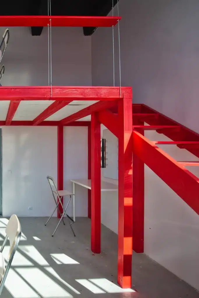 Estructura metálica para altillo con escalera de acceso de chapa perforada y barandilla perimetral en nave industrial del Vallès Occidental