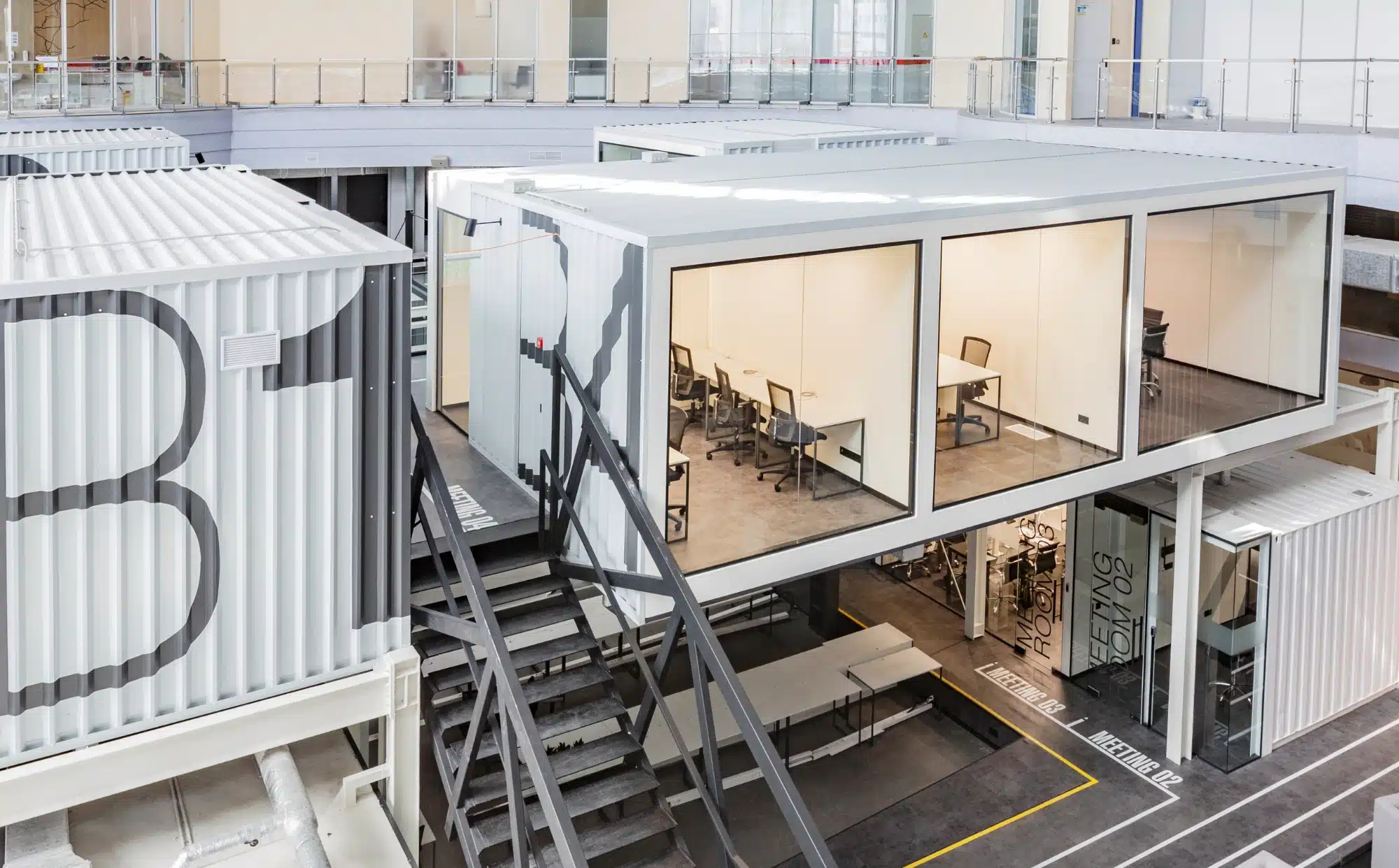 Altillo metálico industrial con oficina acristalada y escalera metálica de acceso en nave de producción del Baix Llobregat