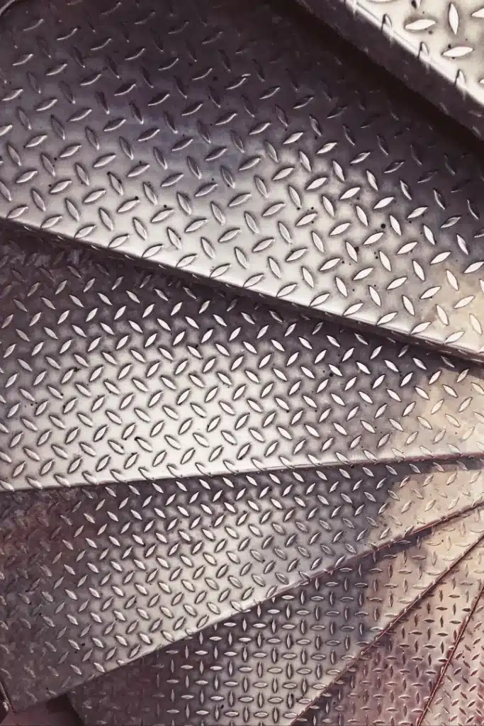 Peldaños de chapa lagrimada antideslizante en escalera metálica industrial fabricada a medida
